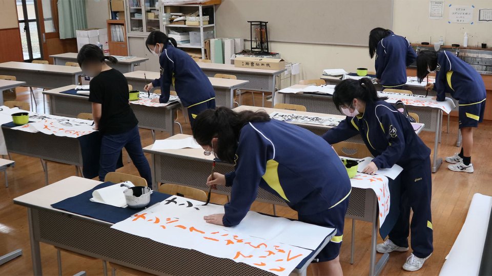 曲を聞きながら練習中の書道部